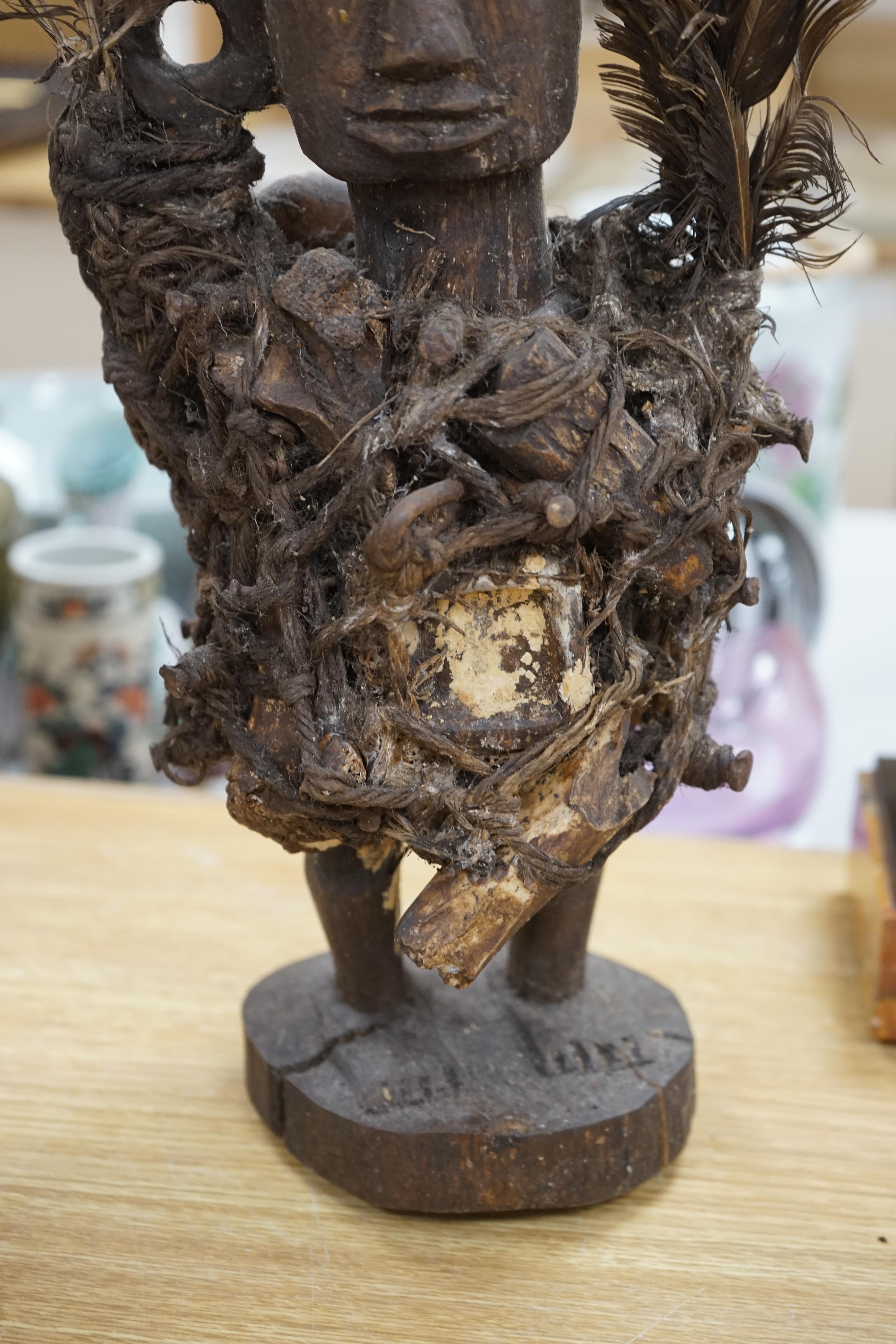 A Congo wood, feather and bone fetish figure, 39cm high. Condition - fair